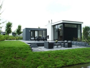 A modern house with a patio, outdoor seating, and a small garden. - Holiday Home in Velsen-zuid With Terrace (Velsen-Zuid)