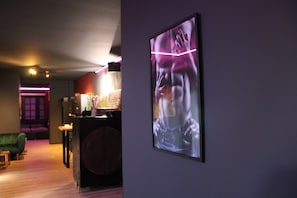 Ein Zimmer mit einem grünen Sofa, einem kleinen Tisch und einem an der Wand hängenden Bild.