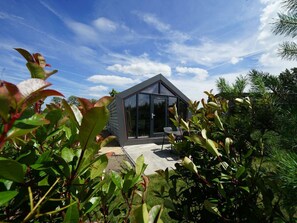 Ein modernes Haus mit Glasfassade, umgeben von üppiger Vegetation.