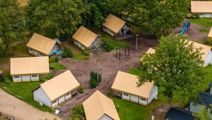 A campsite with multiple tents, a playground, and surrounding greenery. - Glamping Tent Luxe 4 (Kaatsheuvel)