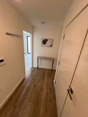 A hallway with a bench, a coat rack, and a door.
