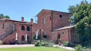 Un bâtiment en briques doté d’une cour, d’un espace extérieur aménagé pour s’asseoir et d’un moulin à vent.