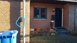 A brick building with a window, a door, and a blue object on the ground. - Apartment "For 4 Guests, 83 m²" with Wi-Fi (Zülpich)