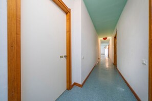 A narrow hallway with wooden doors and a blue carpet. - A comfortable 53-square-meter apartment, perfect for four people, located on the third floor (Scala A) of a building with an elevator (NOT suitable for people with disabilities) directly facing the seafront.The property is located in Lignano Sabbiadoro i (Lignano Sabbiadoro)
