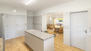 A modern kitchen with white cabinetry, a granite countertop island, and wooden flooring. - Villa Dean Private Pool For Families AC WI- (Lagos)
