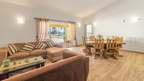 A living room with a sofa, coffee table, and dining area with wooden chairs and a table. - Villa Dean Private Pool For Families AC WI- (Lagos)