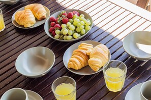A table with plates of croissants and grapes, and glasses of orange juice. - Marina Park 2015 in Lagos (Lagos)