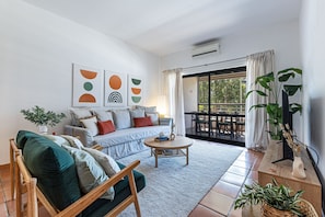 A living room with a sofa, a coffee table, a TV stand, and a balcony with outdoor furniture. - Marina Park 2015 in Lagos (Lagos)