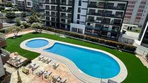 A modern apartment complex with a swimming pool and outdoor seating area. - Praia da Rocha Pet Friendly By the Beach (Portimão)