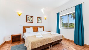 A bedroom with a bed, two bedside tables, a window with curtains, and wall-mounted lights. - Porto de Mos - Nucleo 2 (Lagos)