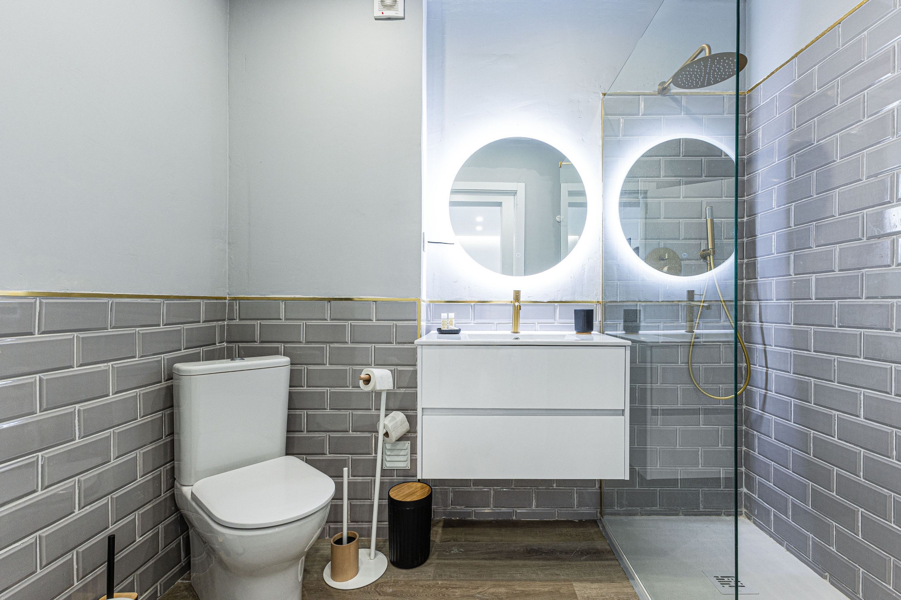 Een moderne badkamer met toilet, wastafel en douche.