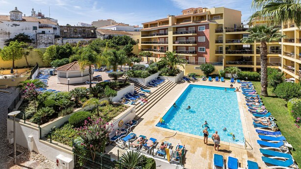 A hotel with a swimming pool, lounge chairs, and a garden area. - Pateo do Convento in Lagos (Lagos)