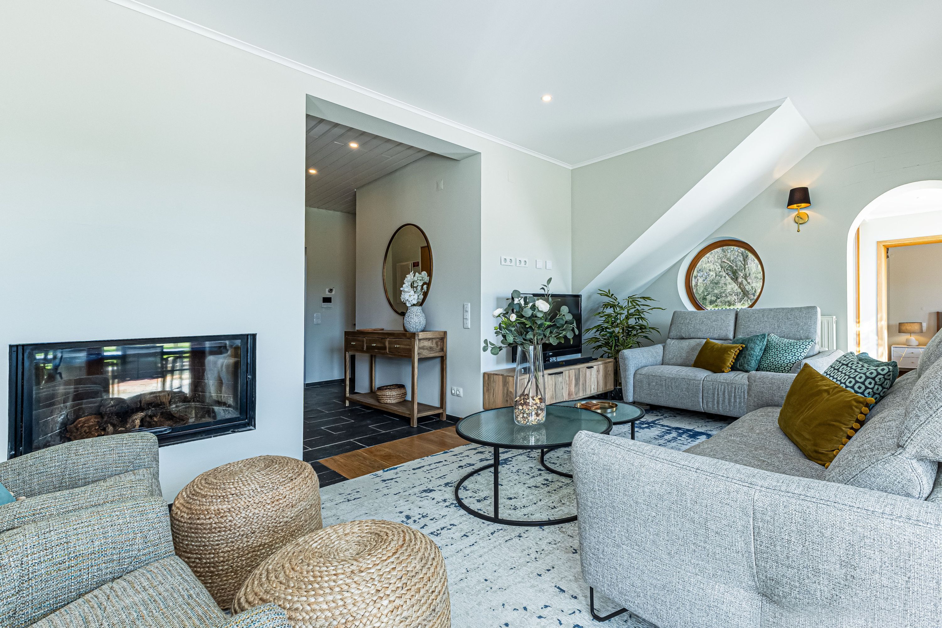 Ein modernes Wohnzimmer mit Kamin, einer Sofagarnitur, einem Couchtisch und einem Essbereich.