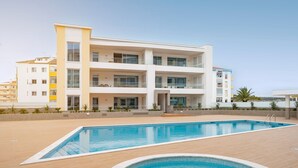 A modern building with a swimming pool, balconies, and a clear sky. - Adega Luxury Near Lagos City Center With Pool (Lagos)