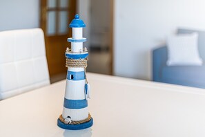 A small, white and blue lighthouse model on a table. - Joia Da Rocha Beach Parking (Portimão)