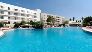 A swimming pool surrounded by white buildings with balconies, palm trees, and lounge chairs. - Marina Garden View in Lagos (Lagos)