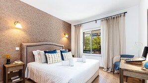 A hotel room with a bed, bedside tables, a desk with a laptop, and a window with curtains. - Marina Garden View in Lagos (Lagos)