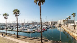 A marina with boats docked, palm trees, and a clear sky. - Marina Garden View in Lagos (Lagos)