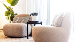 A living room with two armchairs, a small table, and a potted plant. - Marina Garden View in Lagos (Lagos)