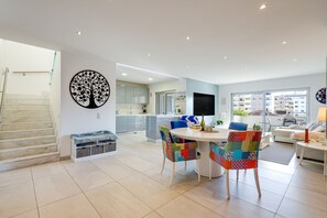Eine moderne Wohnung mit Essbereich, Küche, Wohnzimmer und einer Treppe.