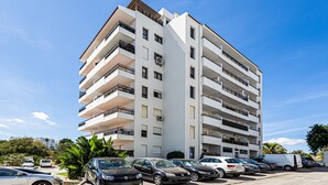 A multi-story building with balconies, a parking lot, and a clear sky. - Encosta do Vau in Portim o (Portimão)