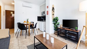 A modern living room with a dining area, a kitchen, and a TV on a wooden stand. - Encosta do Vau in Portim o (Portimão)