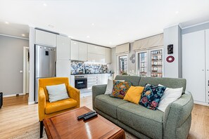 Ein modernes Wohnzimmer mit einer Couch, einem Couchtisch und einem gelben Sessel.