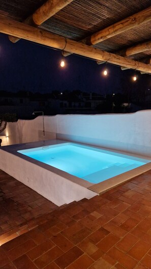 An outdoor swimming pool with a wooden pergola overhead. - Casa Oliva Ref gio Rural Contempor neo (Beja)