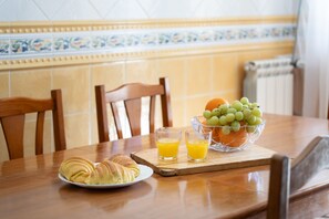 A dining table with croissants, a bowl of grapes, and glasses of orange juice. - Casa Thalassa Portim o (Portimão)