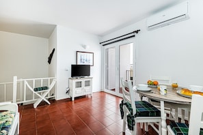 A dining area with a table, chairs, and a television. - Azure Carvoeiro in Carvoeiro (Lagoa)