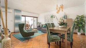 A dining area with a wooden table, striped chairs, and hanging pendant lights. - Sea La Vie On the Beach City Center Marina (Lagos)