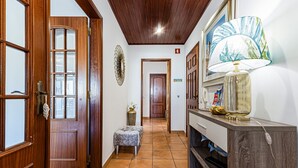 A hallway with wooden doors, a bench, a lamp, and a wall-mounted decorative item. - Sea La Vie On the Beach City Center Marina (Lagos)