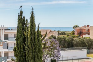 A residential area with buildings, a tree, and a view of the sea. - Casa da Gal Near Meia Praia Perfect Place w S (Lagos)