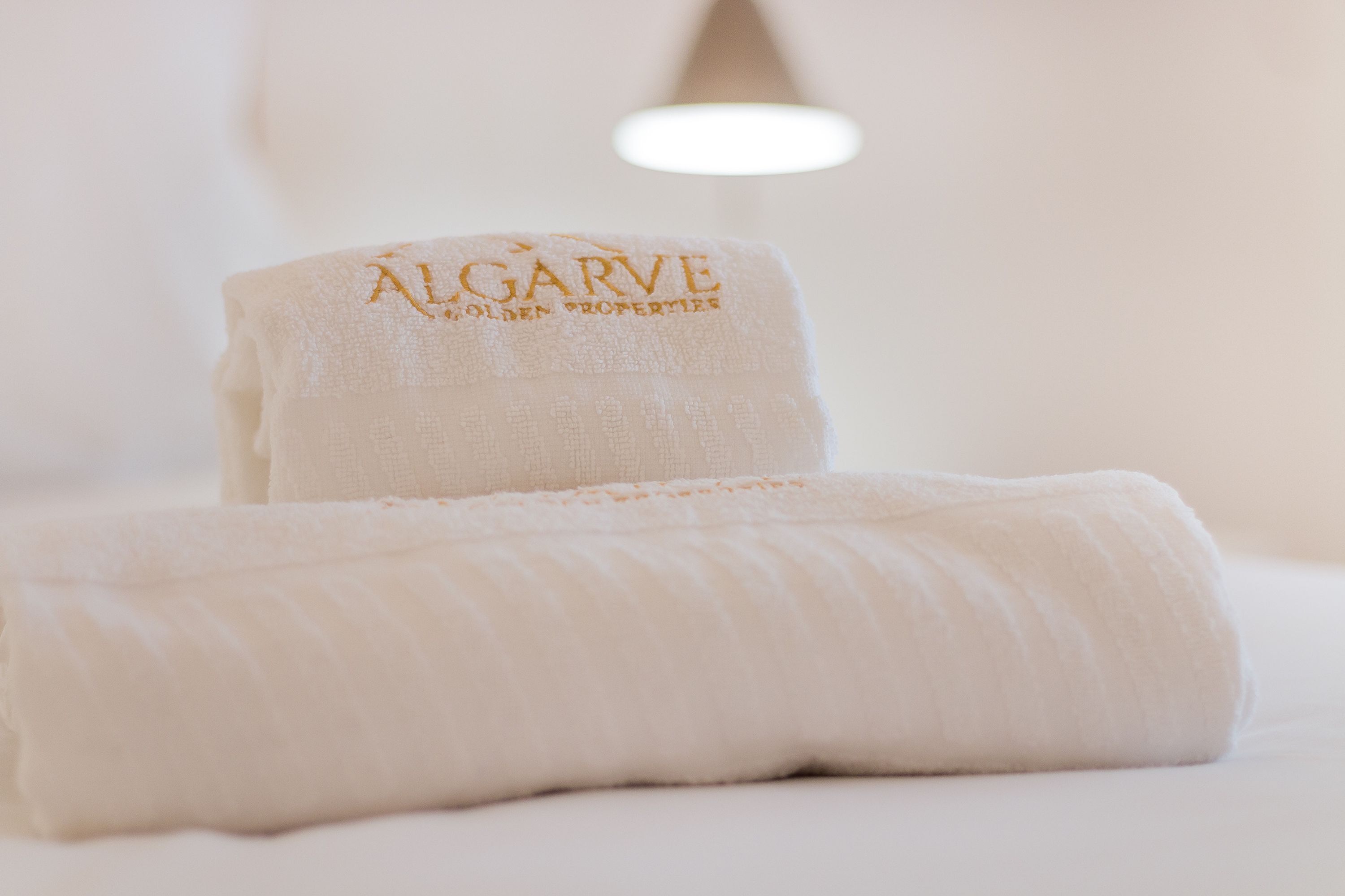 A neatly folded white towel with embroidered text on it.