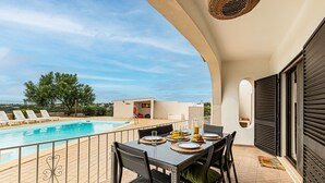 A balcony with a pool, dining table, chairs, and a view of the landscape. - Casa do Vale PET Friendly Pool Lagoa Retreat (Lagoa)