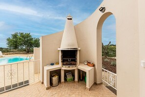 A barbecue area with a pool, outdoor furniture, and a view of the landscape. - Casa do Vale PET Friendly Pool Lagoa Retreat (Lagoa)