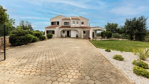 A two-story house with a paved driveway, a covered porch, and a well-maintained lawn. - Casa do Vale PET Friendly Pool Lagoa Retreat (Lagoa)