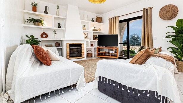 A modern living room with two sofas, a fireplace, a TV, and a balcony with curtains. - Casa do Vale PET Friendly Pool Lagoa Retreat (Lagoa)