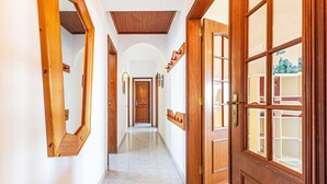 A hallway with wooden doors and mirrors, leading to a room with a view. - Lagos Sea View Near the City Center (Lagos)