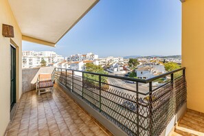 A balcony with a view of a cityscape, a chair, and a railing. - Lagos Sea View Near the City Center (Lagos)