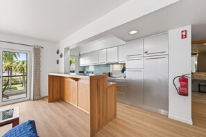 Een moderne keuken met witte kasten, een houten eiland en uitzicht op de omgeving.