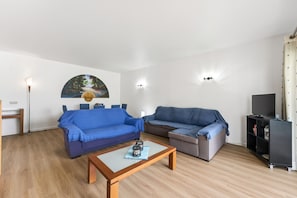A living room with two sofas, a coffee table, a painting, and a TV stand. - Marina Breeze By the Marina City Center Beach (Lagos)