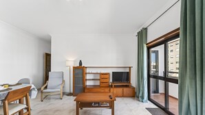 Ein modernes Wohnzimmer mit einem Holztisch, einem Fernseher und einem Essbereich.