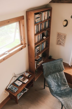 Una habitació amb una prestatgeria de fusta, un sofà de pell i una finestra.