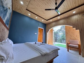 A bedroom with a bed, a wooden ceiling, a blue wall, and a view of the outdoors. - Seraahi Hills Resort (Doda)