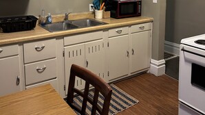 A kitchen with white cabinets, a microwave, a sink, and a stove. - Bright apartment in quaint Fargo with refreshing AC (Fargo)