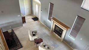A spacious living area with a fireplace, two white leather sofas, a wooden coffee table, and a patterned rug. - Waterfront Granbury Getaway — 5BR, Dock & Putting Course (Granbury)