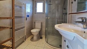 A modern bathroom with a glass shower enclosure, a toilet, and a sink. - Comfort 4 Persons (Egmond aan den Hoef)
