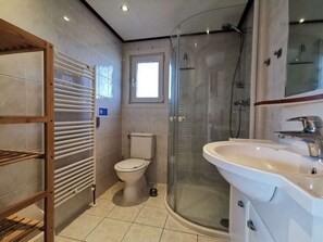 Ein modernes Badezimmer mit Duschkabine aus Glas, Toilette und Waschbecken.
