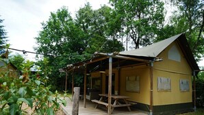 A small yellow cabin with a wooden deck, a picnic table, and a covered seating area. - Holiday Home in Otterlo With Terrace (Otterlo)